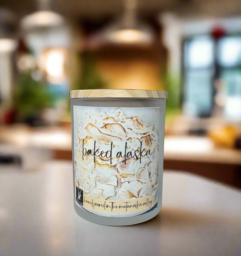 Candle with 'baked alaska' label on a blurred kitchen background
