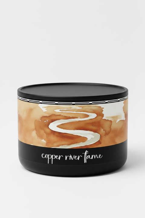 matte black tin candle featuring a watercolor-style illustration of a winding white river through warm copper-brown land, with the text 'copper river flame' in white script on a black background below, by grey fox candles