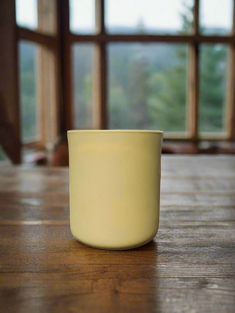 Goldenrod colored jar with a blurred window background