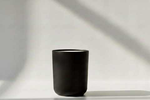 Black matte candle jar in a white studio setting.