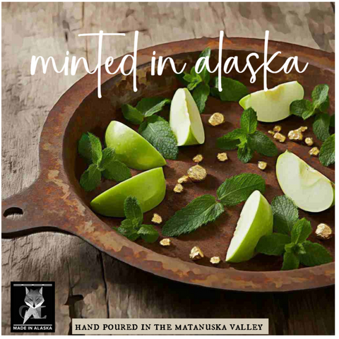 Minted in Alaska candle with green apples and mint leaves on a rustic wooden background