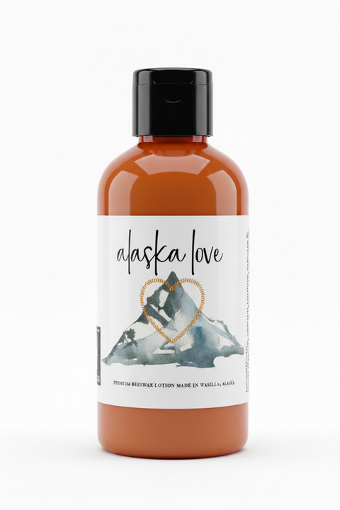 Alaska Love premium beeswax lotion label featuring a watercolor mountain with a heart-shaped gold border outline and a grey fox logo on a white background.