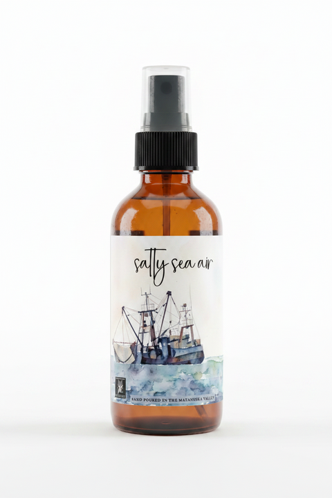 salty sea air linen spray featuring a watercolor painting of a fishing boat on blue-green waves, with the text 'HAND POURED IN THE MATANUSKA VALLEY' , made in alaska by grey fox candles