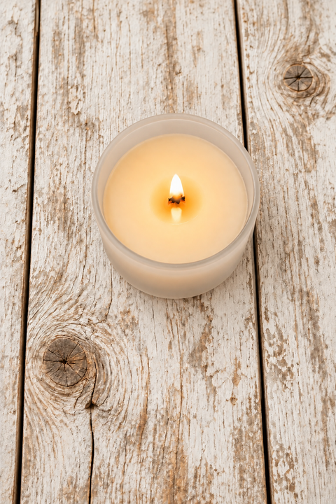 Candle in a frosted glass jar; wood wick burning