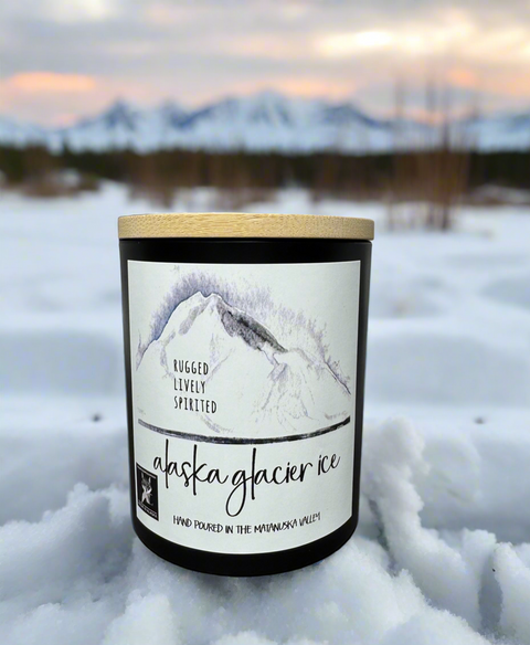 Candle labeled 'Alaska Glacier Ice' in a snowy landscape with mountains in the background