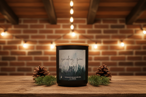 Smoky pine candle glowing in a lodge setting with warm Edison bulb lighting