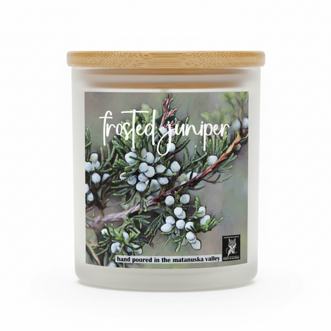 Candle jar with 'Frosted Juniper' watercolor art label featuring a branch of juniper berries on a white background. text says 'hand poured in the matanuska valley" and made in alaska logo by grey fox candles.