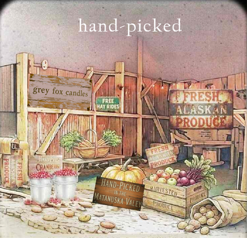 Vintage-style illustrated sign collage with rustic wooden fencing, crates of apples and potatoes, baskets of greens, and handwritten signs including 'hand-picked', 'Fresh Alaskan Produce', and 'Grey Fox Candles'.