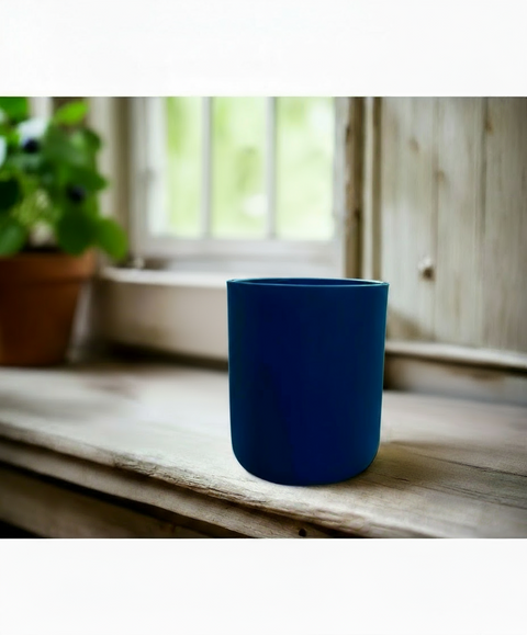 matte blue glass candle jar on a wooden surface with a blurred background by grey fox candles