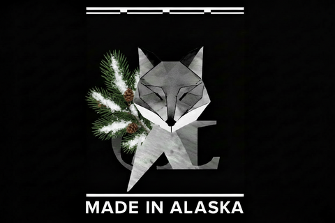 Geometric fox design with pine branches and 'Made in Alaska' text on a black background