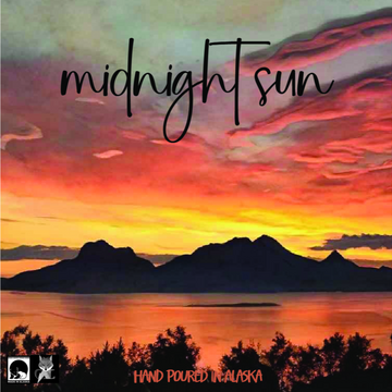 Sunset over mountains with 'midnight sun' text and 'Hand Poured in Alaska' at the bottom.