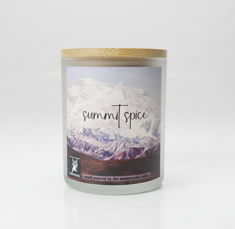Candle labeled 'summit spice' in a frosted white jar