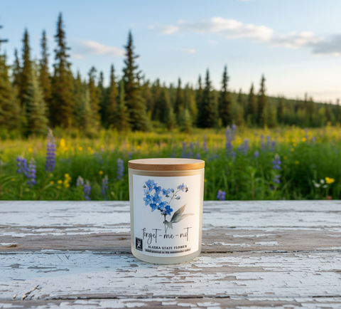 forget me not alaska state flower candle outside on a farmhouse table, on a beautiful Alaska summer day