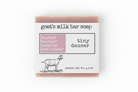 Product label for goat's milk bar soap named 'tiny dancer' by the brand 'tiny dancer'. The label features a white background with black text, a dusty pink block highlighting key certifications, and a black line drawing of a goat.