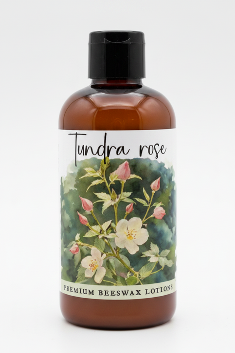 A product information card for Tundra Rose Premium Beeswax Lotions. The card features a central floral illustration of a yellow and white flower with pink buds on a green and blue watercolor background.